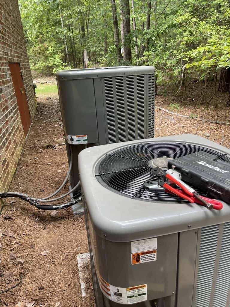 Commercial HVAC unit outside a building in a wooded area, ready for installation or maintenance.