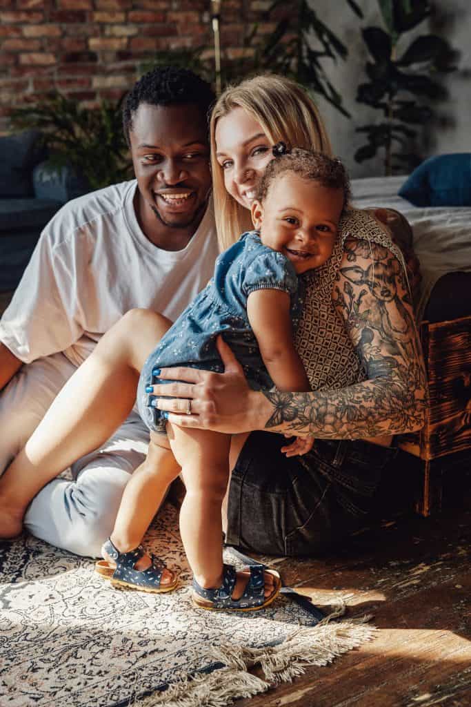 Mixed race family posing together on camera inside room